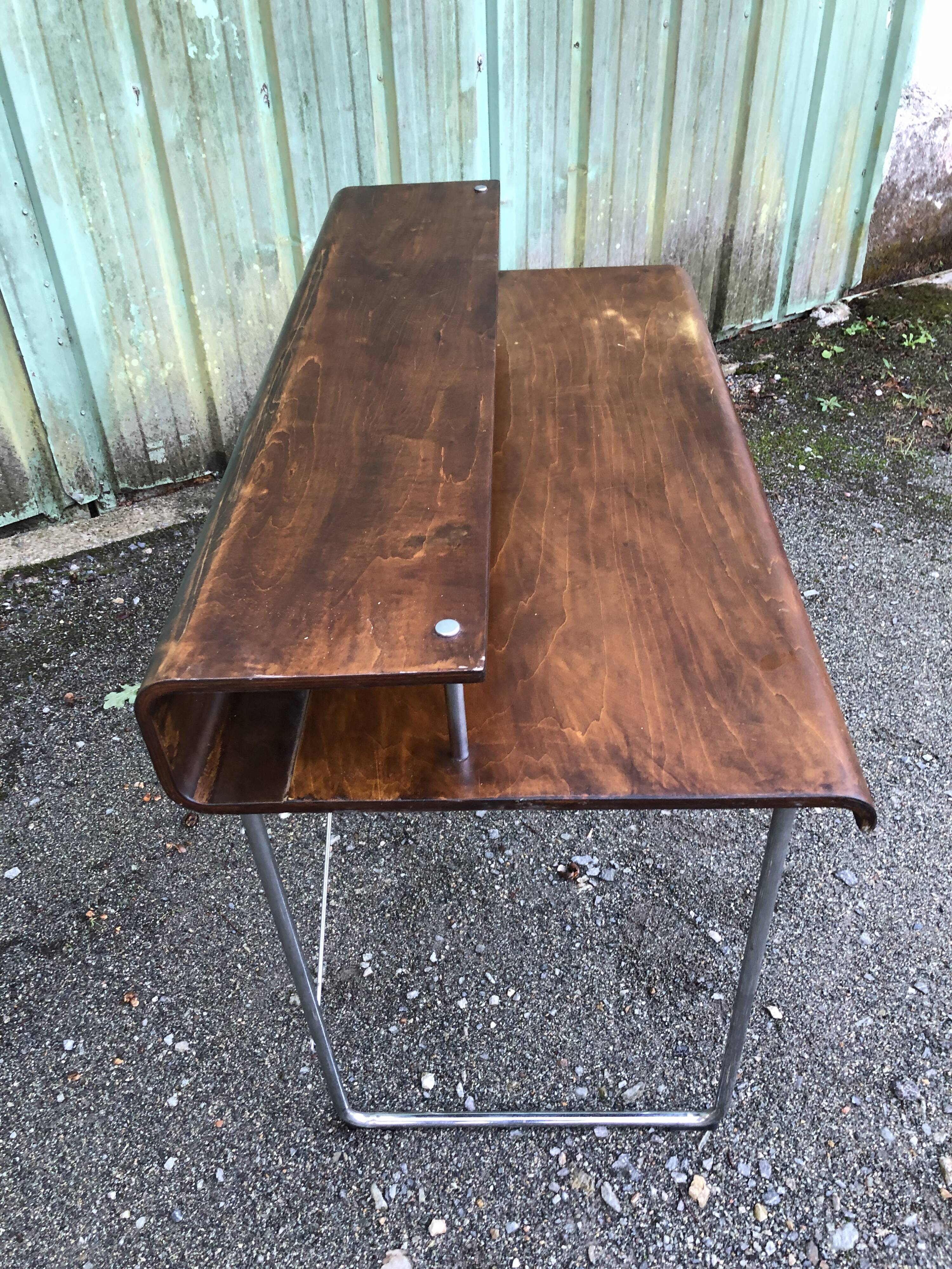 Design desk in formed glued laminated wood with chrome tubular base.