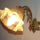 Simple wall sconce in French Art Nouveau bronze with a white glass shade featuring patterns.
