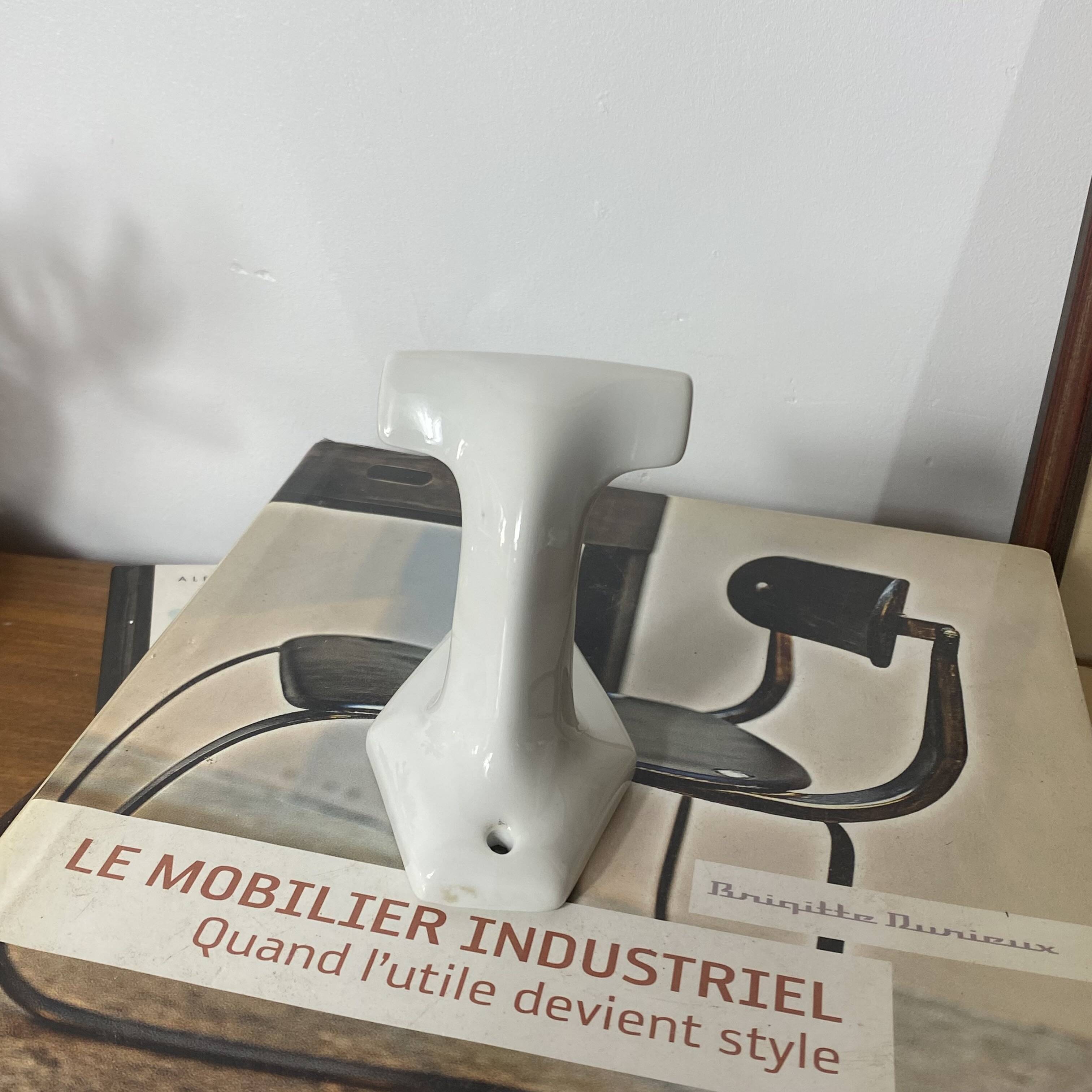 An antique white porcelain coat hook towel holder.