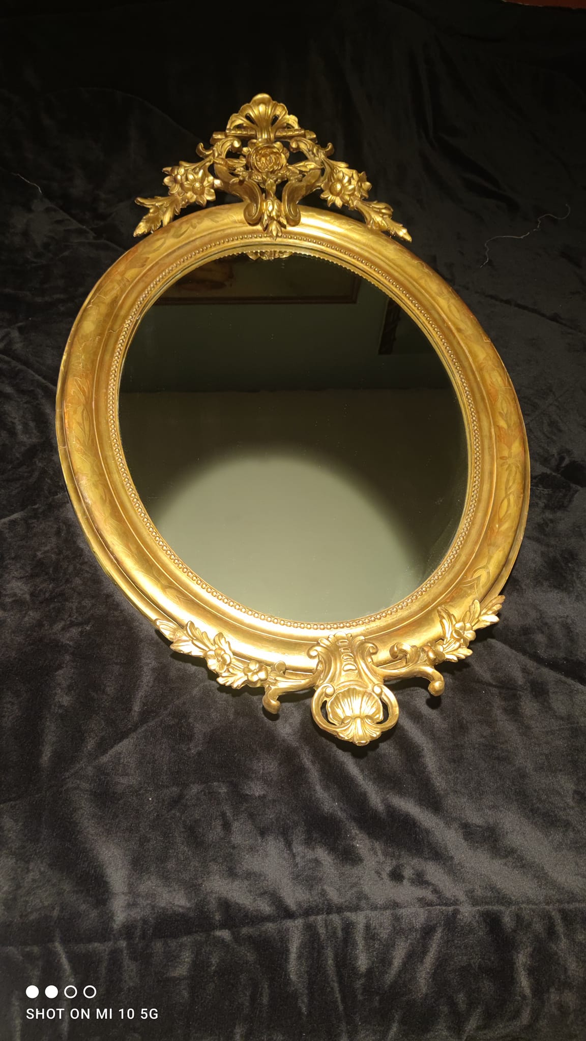 Ovoid mirror with double gilt pediments, circa 1830, 105x66 cm