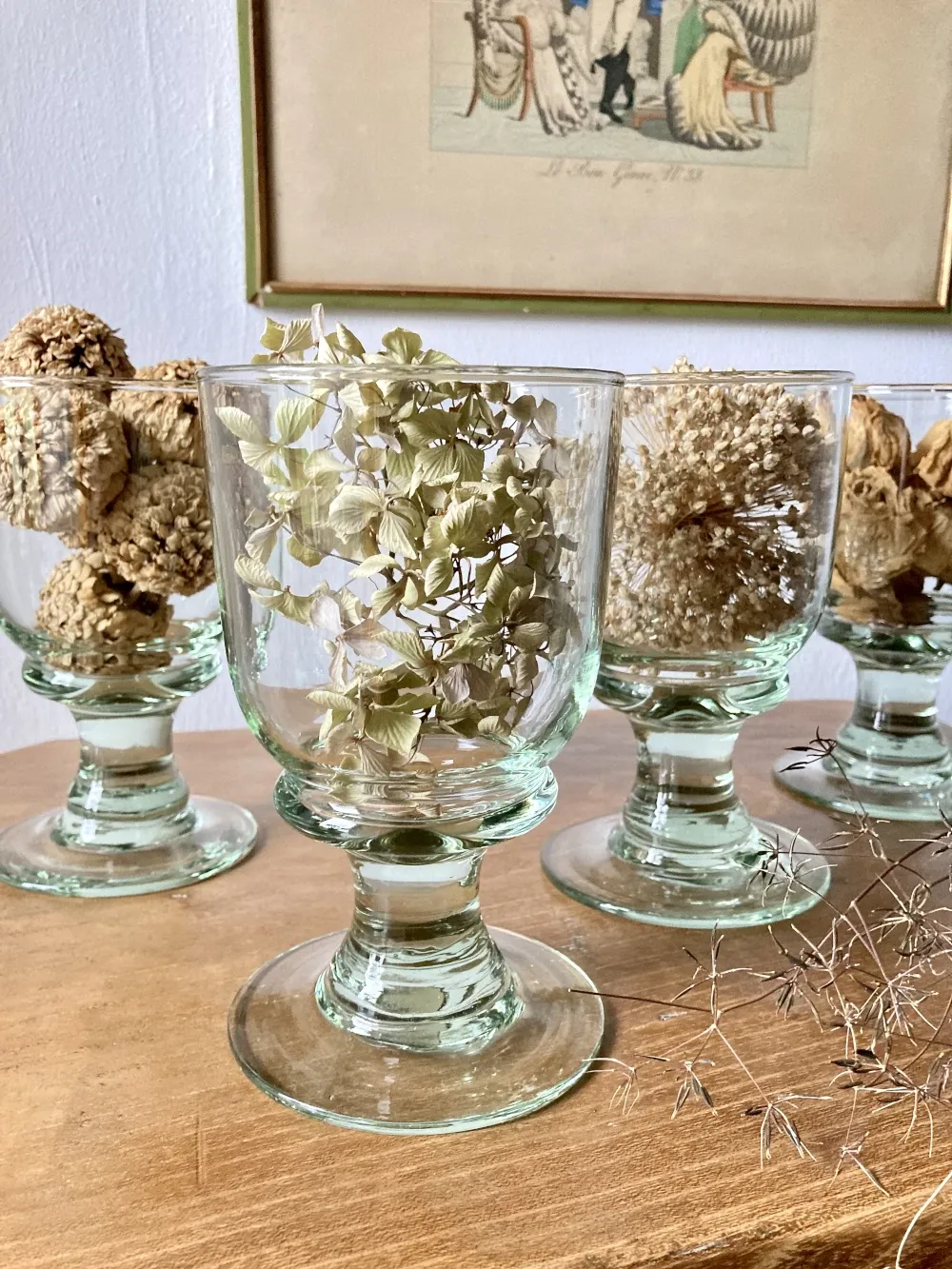 4 stemmed glasses made of handcrafted blown glass in green hue.