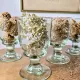 4 stemmed glasses made of handcrafted blown glass in green hue.