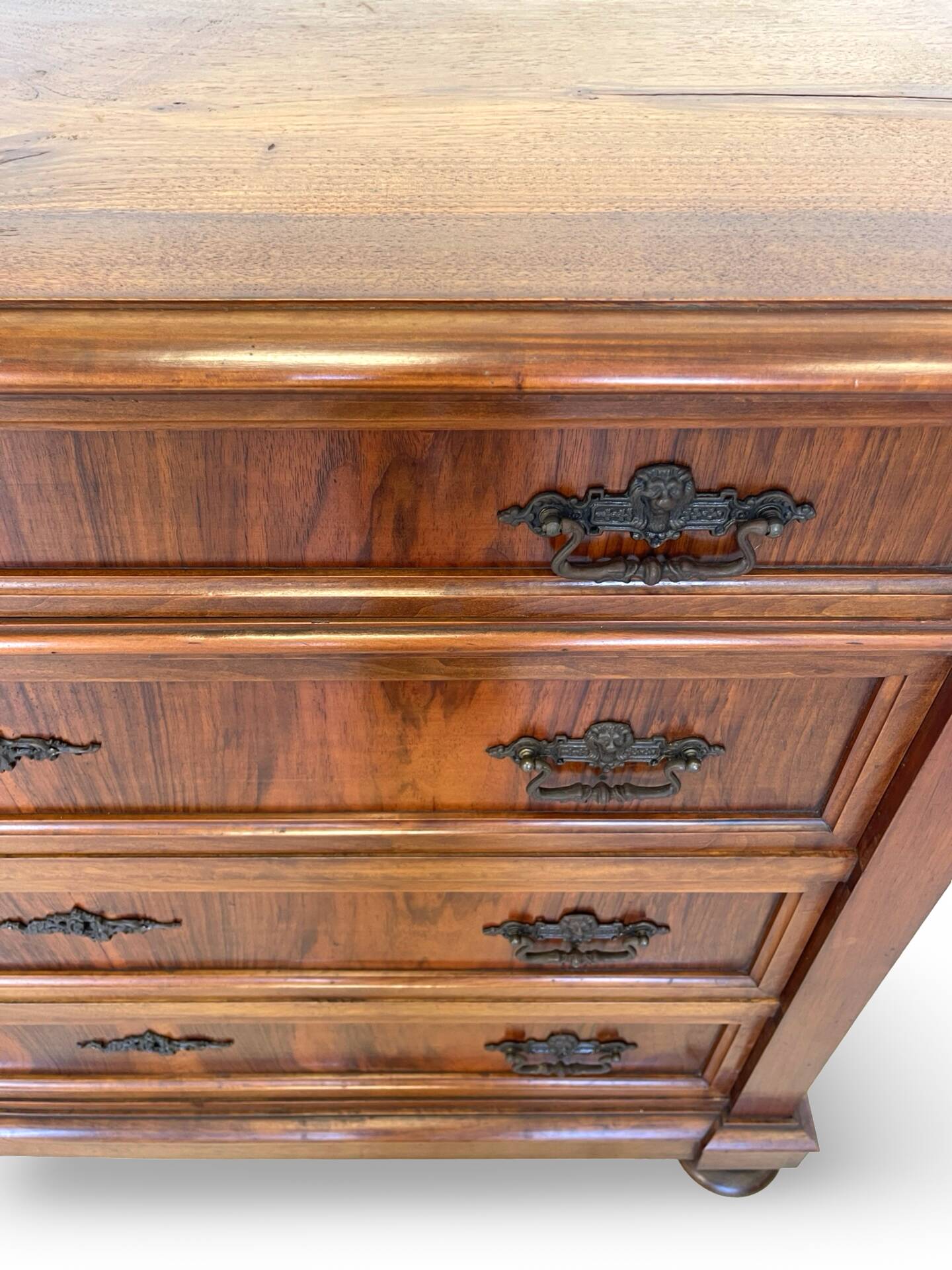 Antique walnut commode with bronze handles in the shape of a lion's mask,