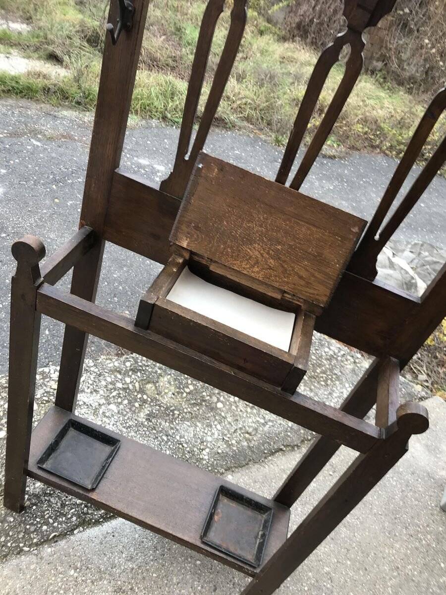 Antique brown wooden coat rack with mirror and umbrella stand, 1900 style.