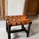 Antique turned wooden stool with woven leather.