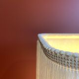 Beige marble stucco base, Houles white ecru fringed lampshade.