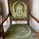 Paire de fauteuils empire en noyer teinté, tissus vert motif de palmette, sculptés têtes de dauphin