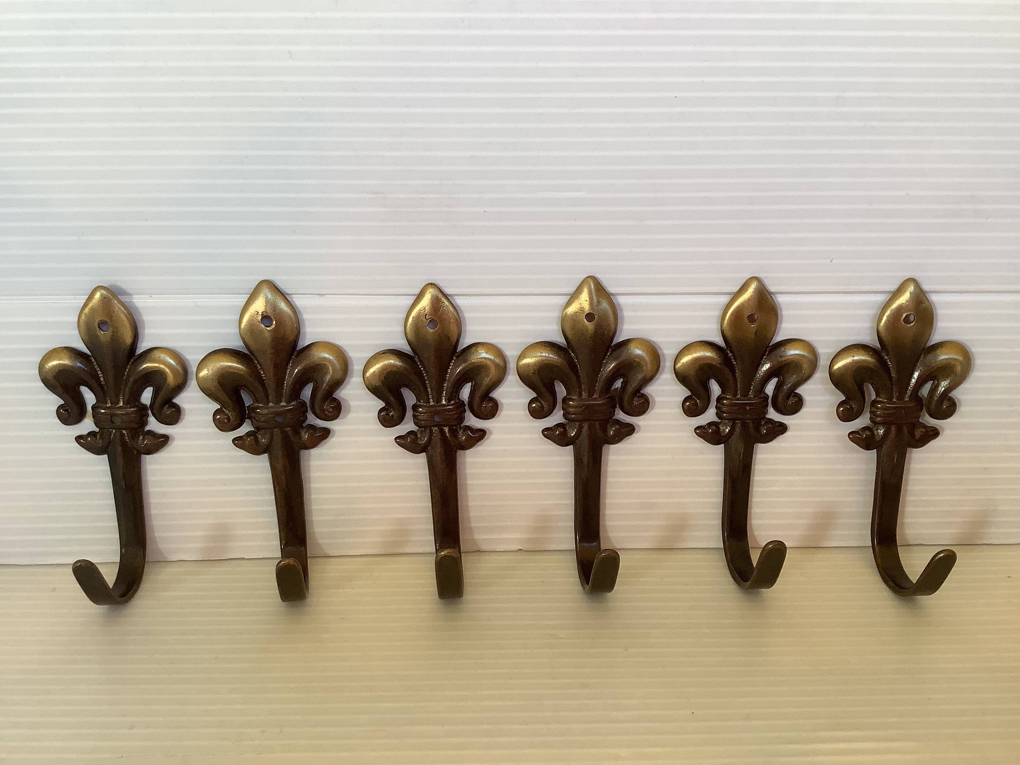 Six metal fleur-de-lys hooks