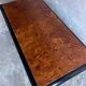 Vintage coffee table in wood burl on a black lacquered base.