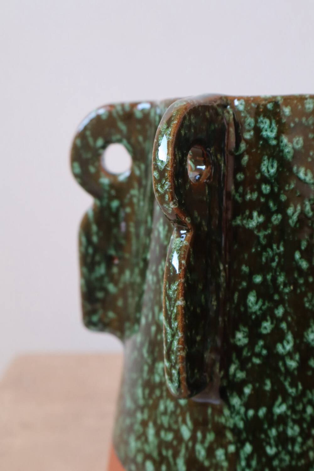 Sculptural ceramic vase with dark green glaze and shimmering highlights