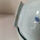 Two vintage farm bowls on a pale blue pedestal with floral decoration.