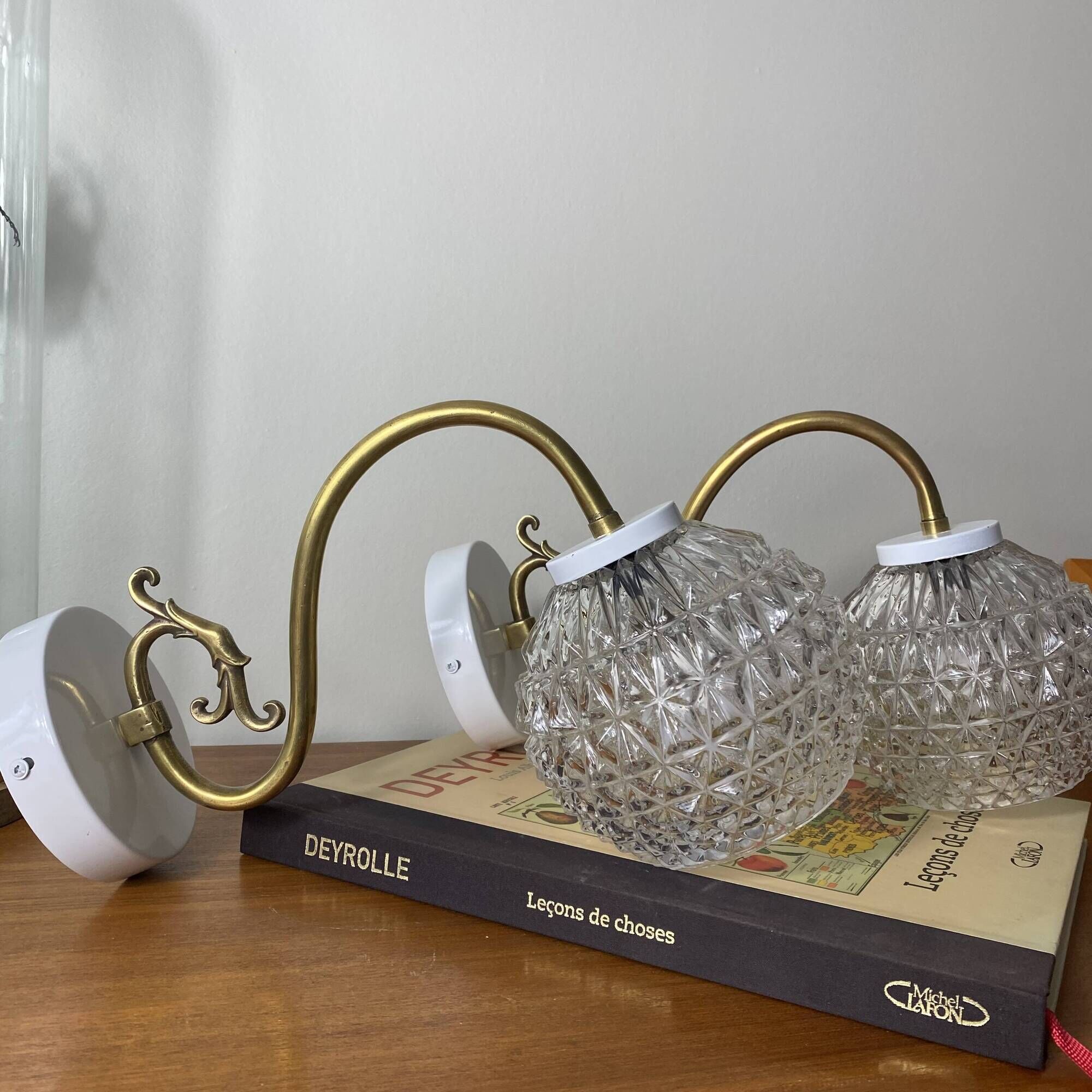 Large pair of brass swan neck wall lights with transparent glass globes.