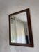 Vintage bevelled wall mirror in stained wood and brass