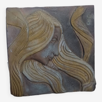 Art Deco style stone bas relief, woman with hair blowing in the wind