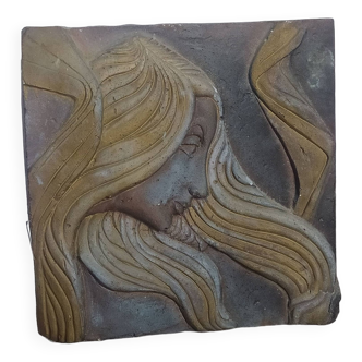 Art Deco style stone bas relief, woman with hair blowing in the wind