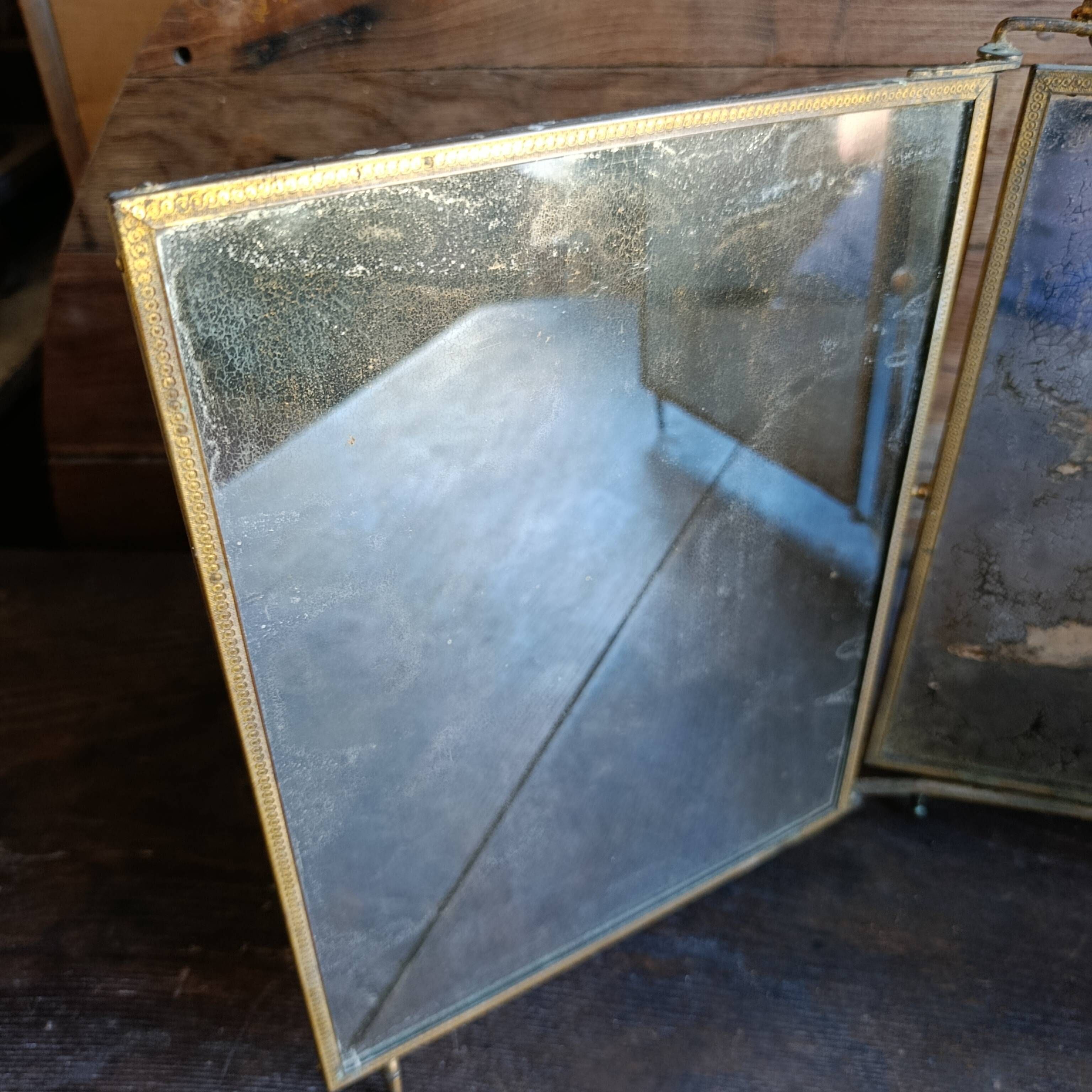 Antique French gilt metal triptych vanity mirror with floral crest