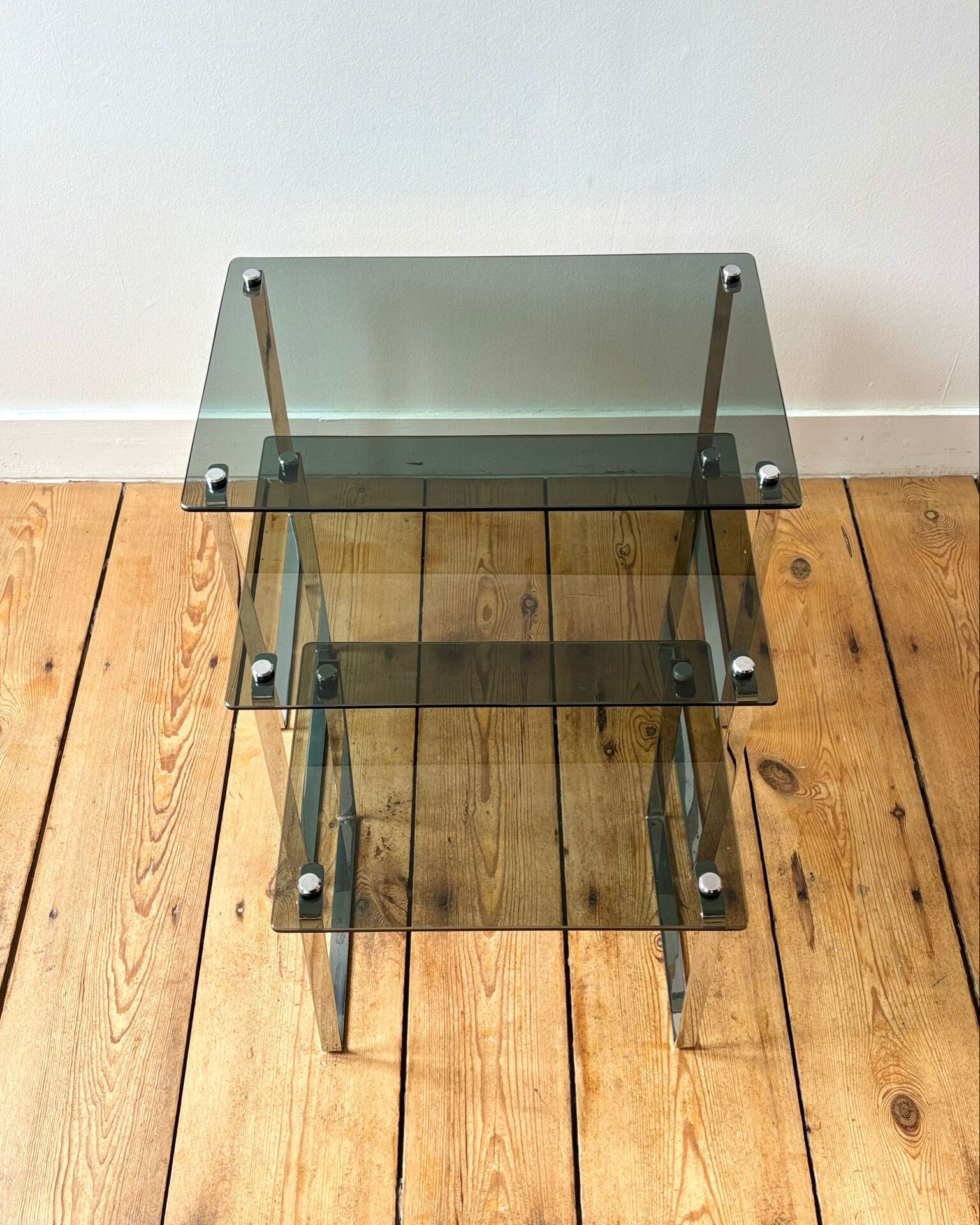 Nest of coffee tables in chrome with smoked glass top.