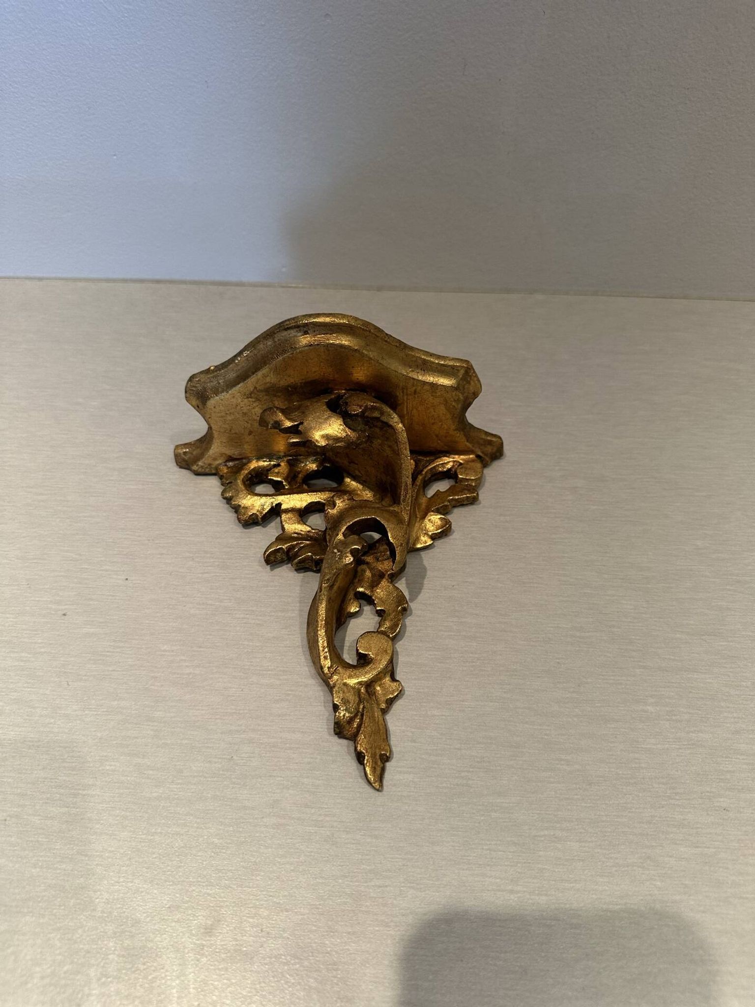 Antique wall-mounted console in gilded wood in rococo style.
