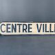 Panneau de signalisation vintage, en bois peint, centre ville.