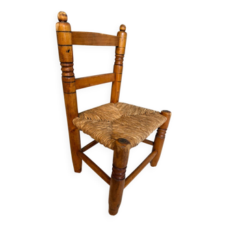 Old, rustic children's chair, small wooden and straw chair.