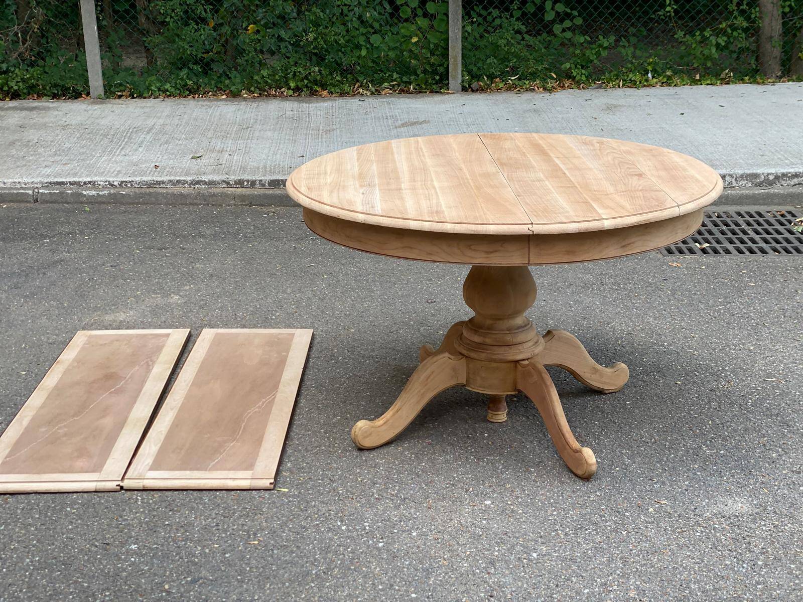 Round dining table with a central pedestal, extendable, stripped in solid walnut with 2 extensions.