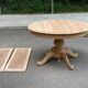 Round dining table with a central pedestal, extendable, stripped in solid walnut with 2 extensions.