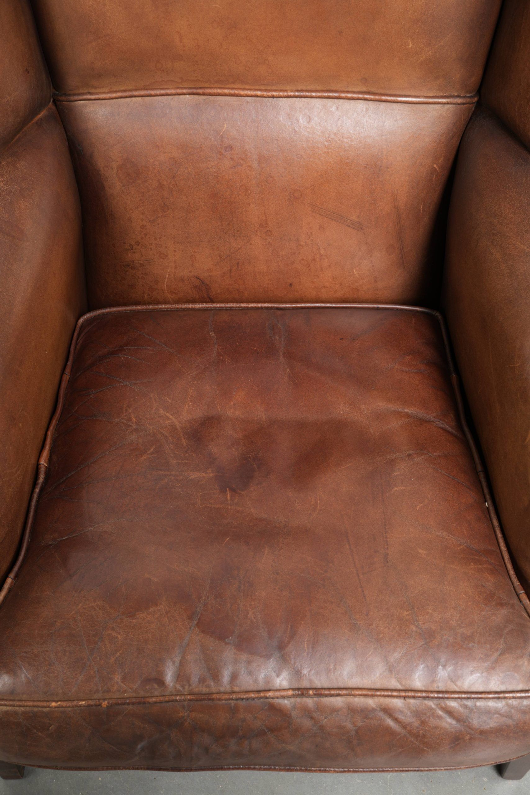 Subtle dark brown sheepskin wingback armchair with a timeless look subtle