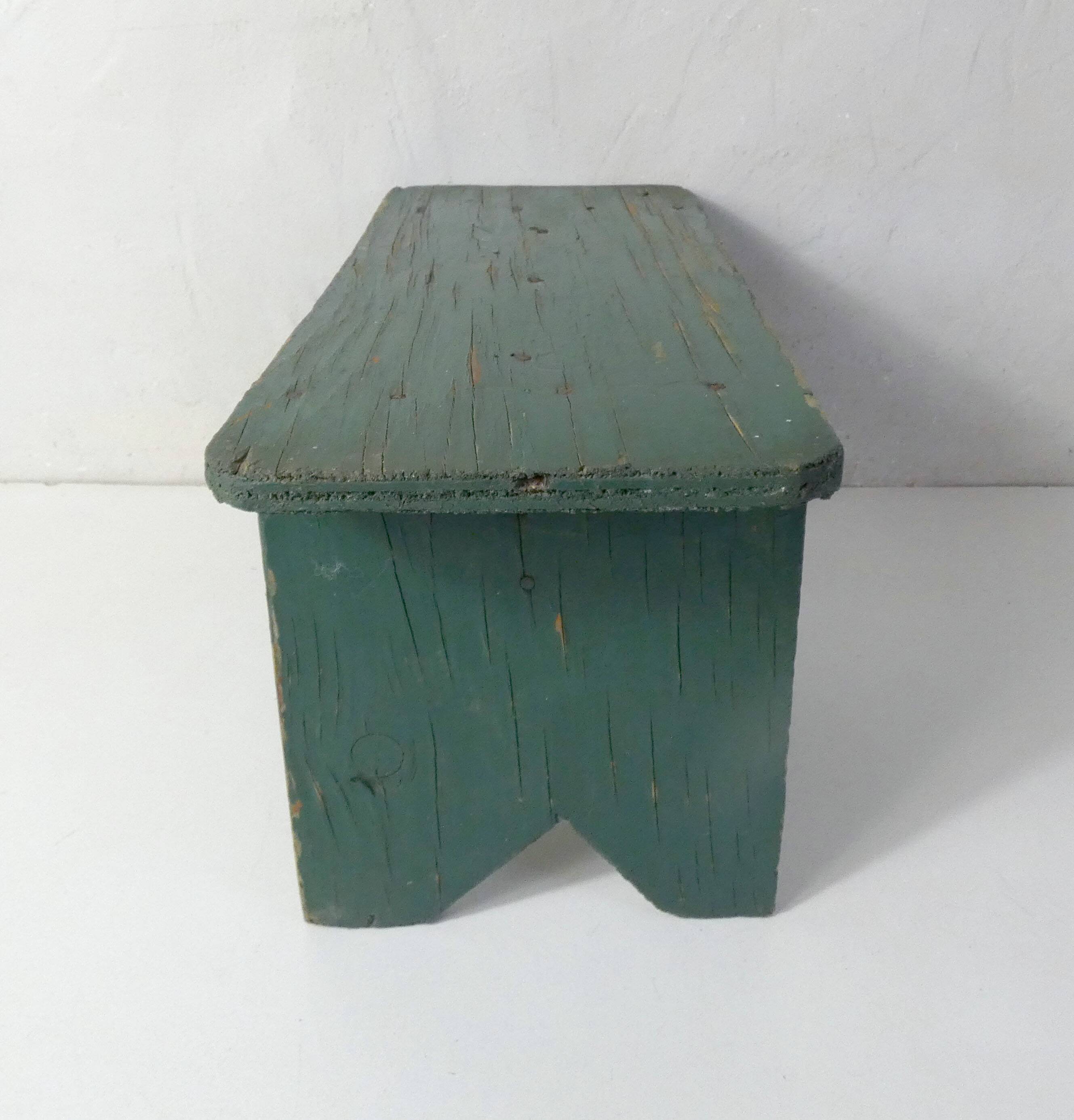 Old small wooden bench with green foot