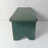 Old small wooden bench with green foot