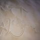 Antique embroidered linen sheet with a monogram.