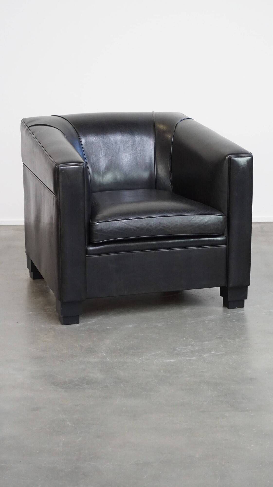 Very comfortable black Art Deco design armchair, made of sheepskin leather