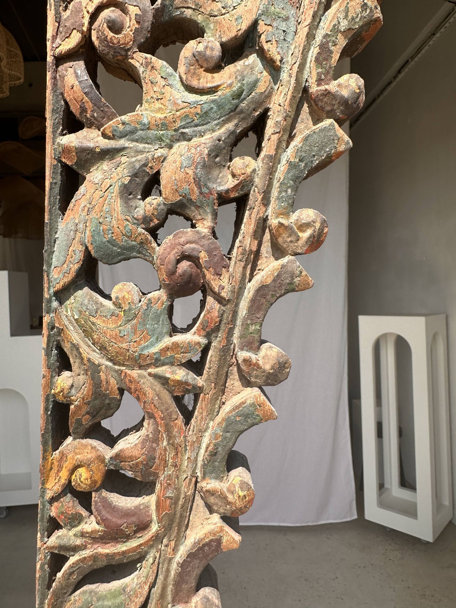 Indonesian construction element in carved wood with intertwined plant motifs mounted on a base (fri