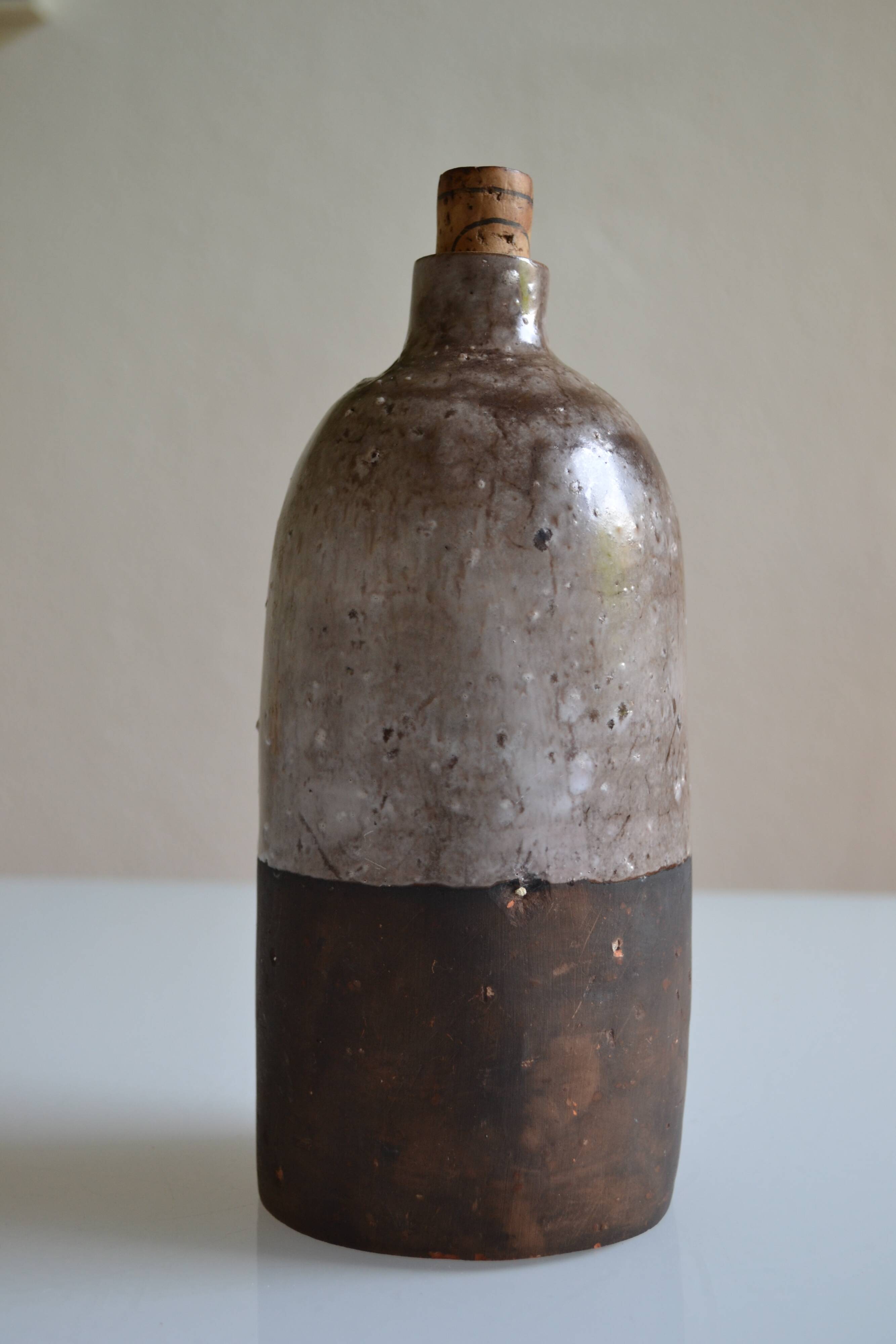 Ceramic bottle vase with a fish signature to be identified.