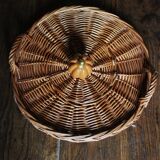 Medium round dark wicker plateau with two handles.