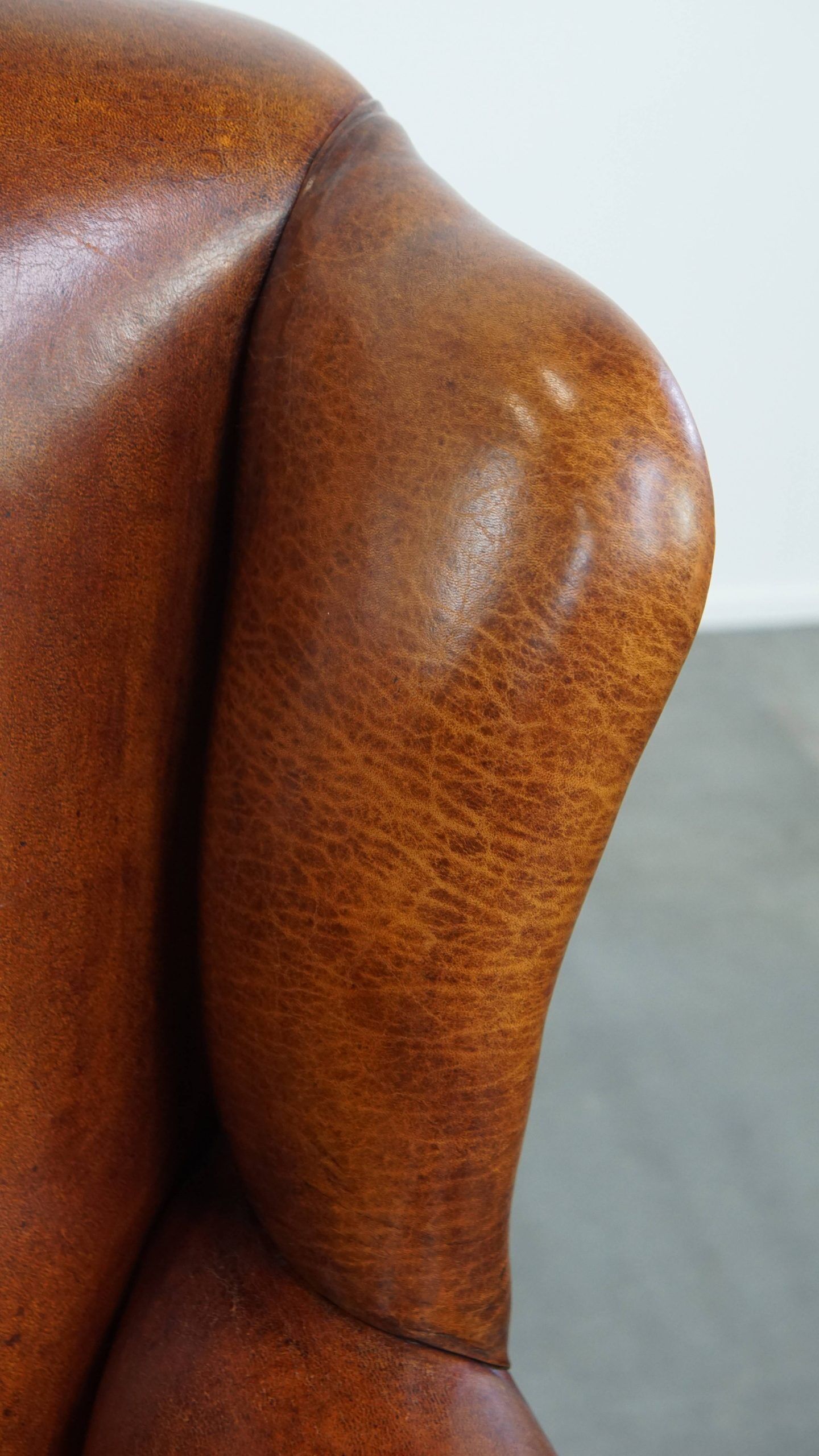 Sheepskin wingback armchair with stitching and black piping