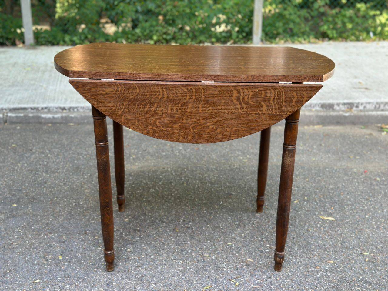 Round kitchen table with extendable leaves in dark wood.
