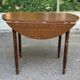 Round kitchen table with extendable leaves in dark wood.