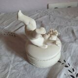 Small round box topped with a vintage biscuit porcelain angel