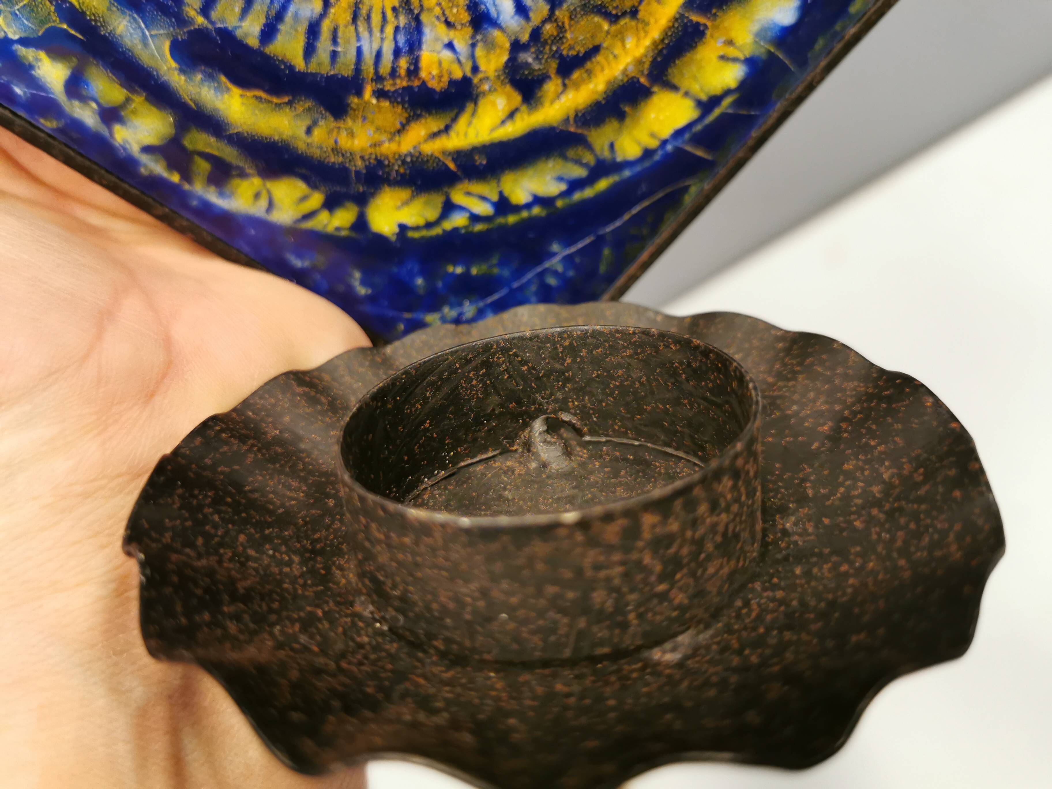 Wall-mounted candle holder in cast iron and ceramic. Estimated Danish and from the 70s.