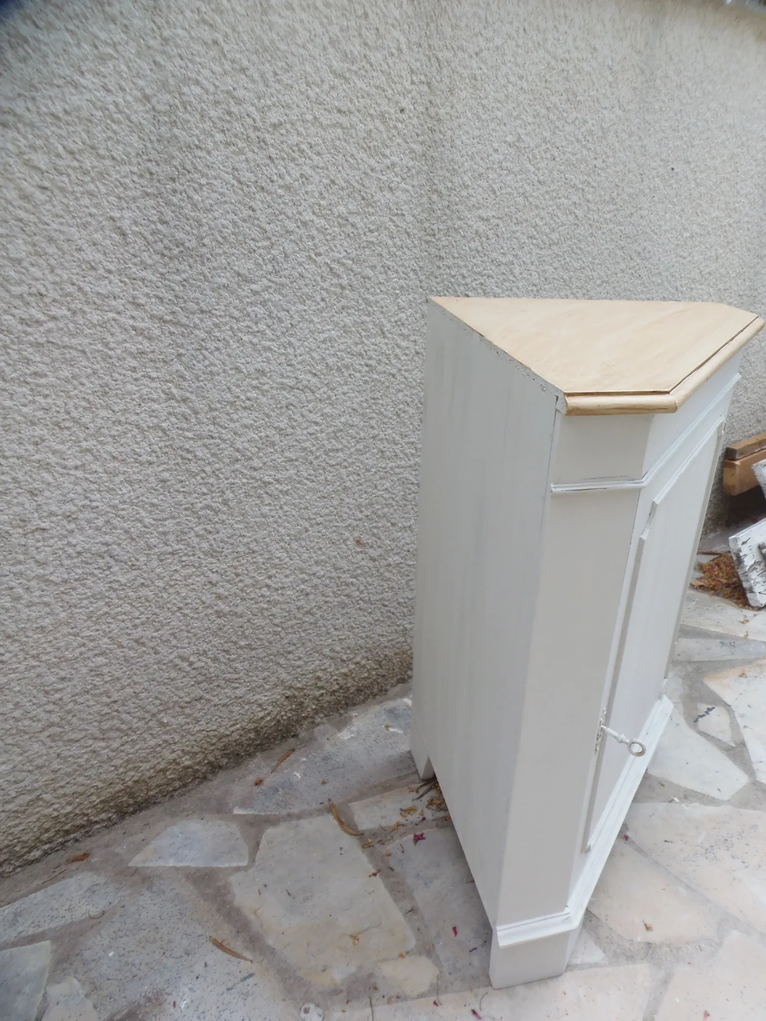 Vintage English corner cabinet enhanced in pearl grey, wooden top.