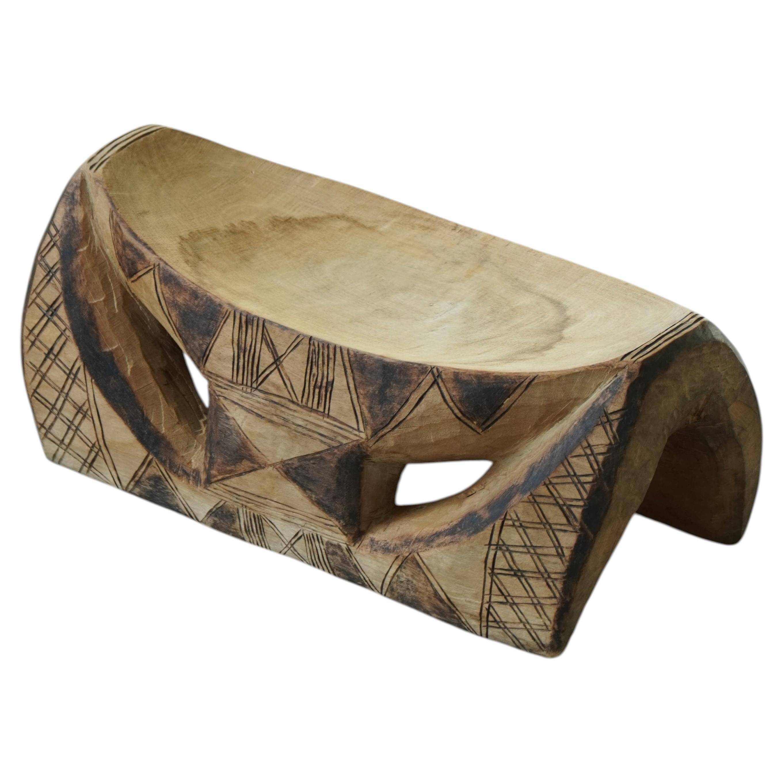 African sculptural stool in wood, hand-carved and adorned with geometric patterns, 1950s.
