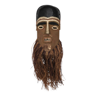 African mask painted in wood with raffia, 1980s.