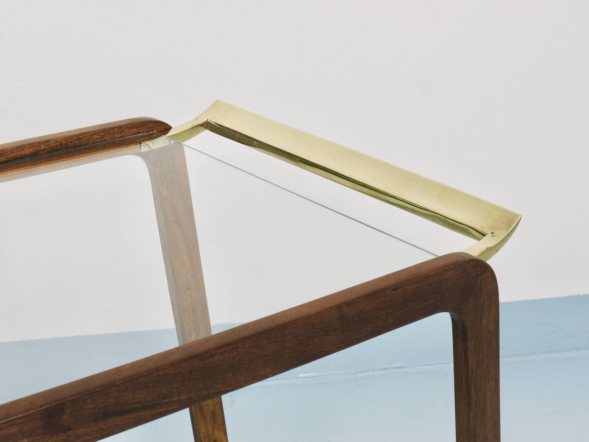 May include: A mid-century modern bar cart with a dark wood frame and two c