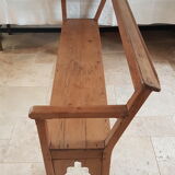 Church bench in fir tree with armrests