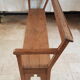 Church bench in fir tree with armrests
