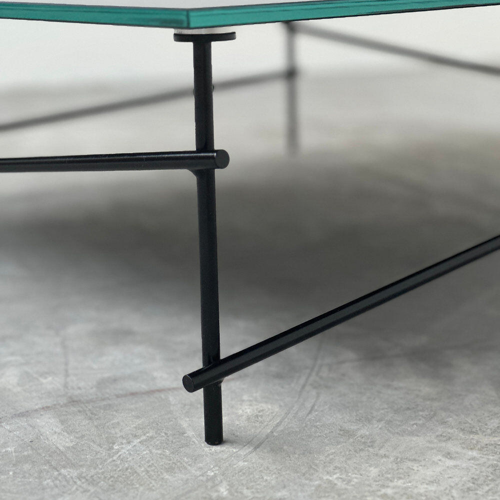 Minimalist black glass coffee table with industrial metal base