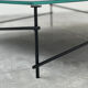 Minimalist black glass coffee table with industrial metal base
