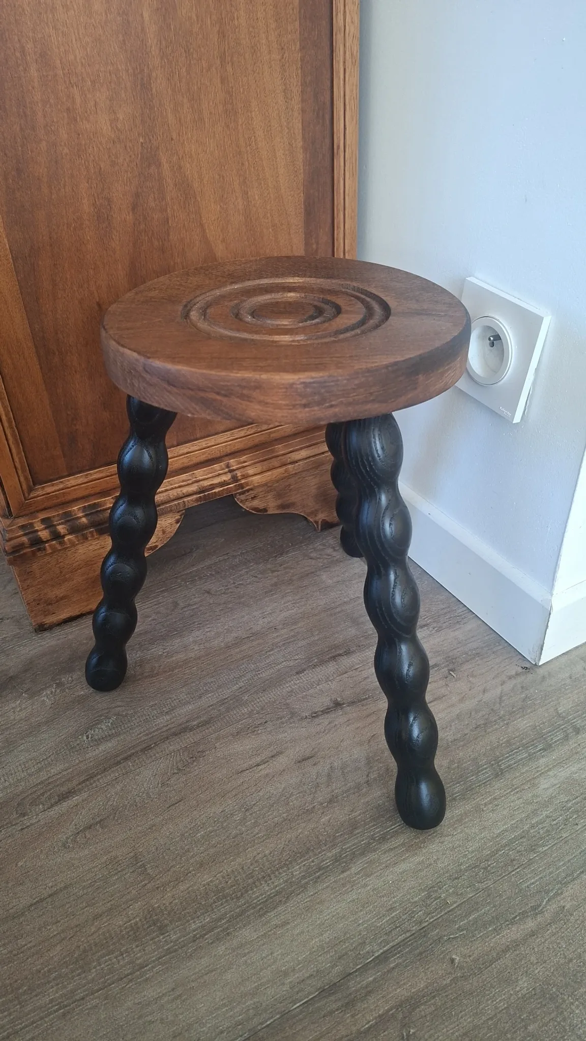 Brown and black wooden tripod stool