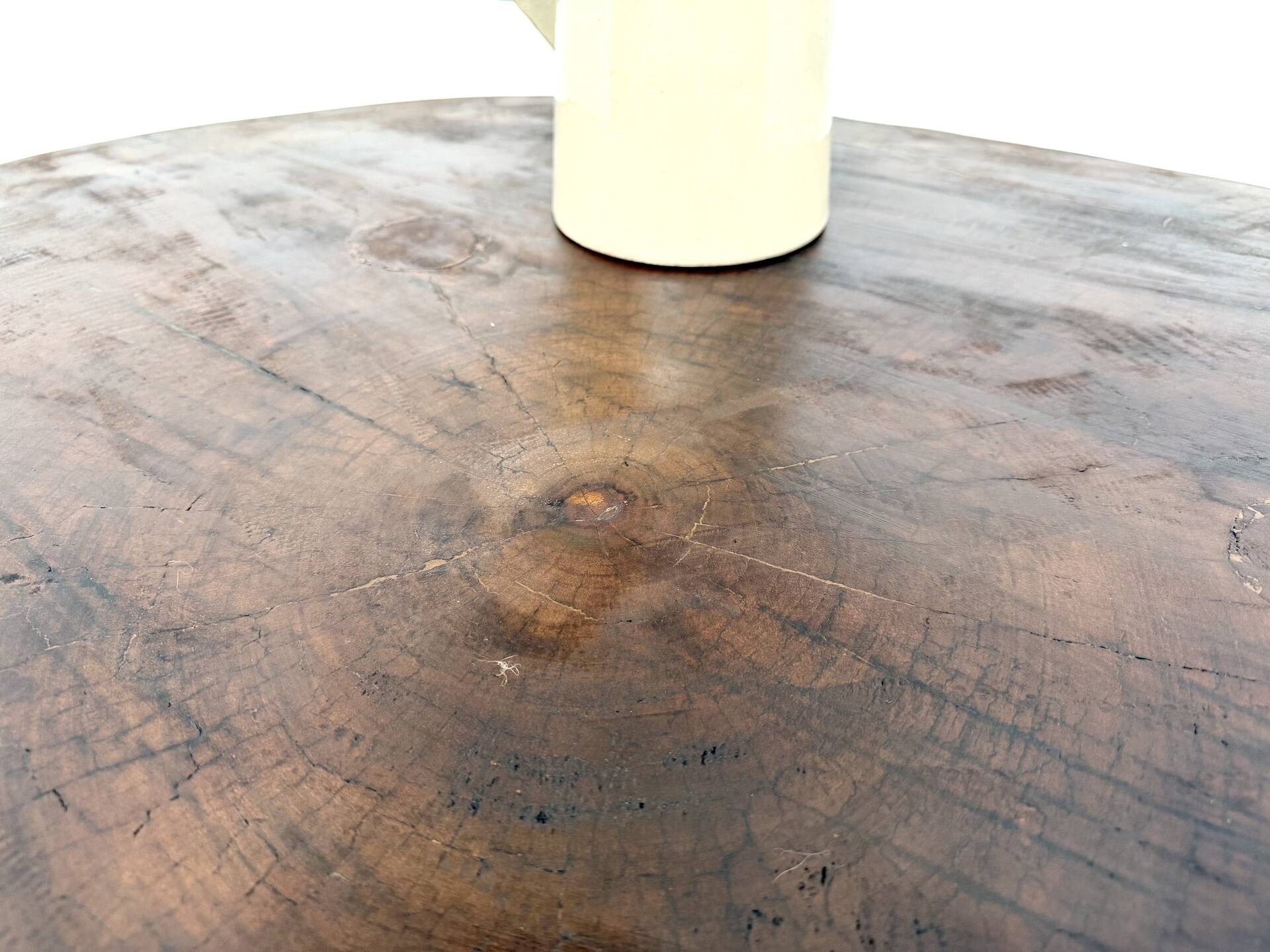 Brutalist coffee table in solid teak, monolithic slab, tripod base.