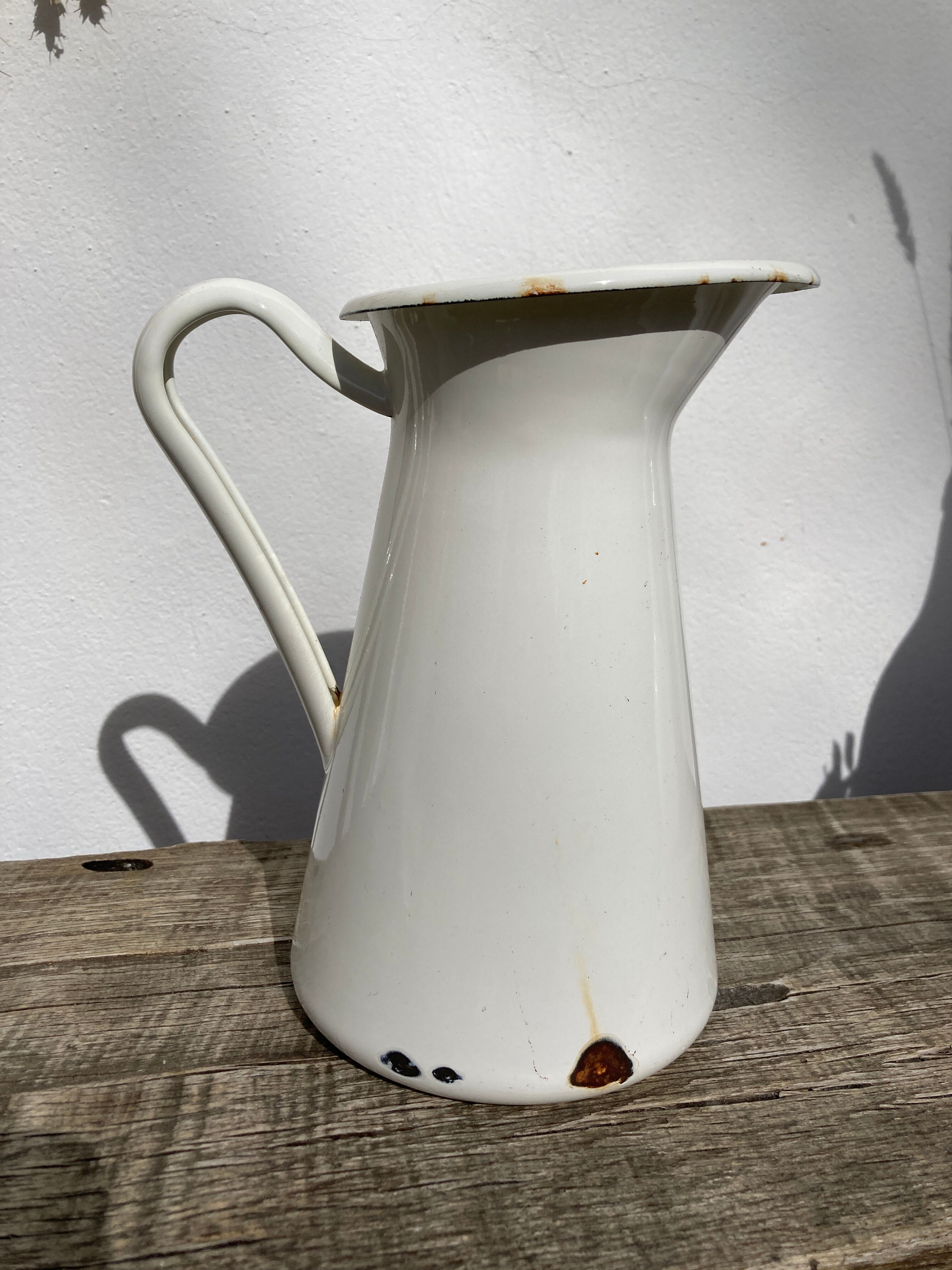 Old white enamelled metal pitcher